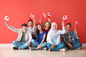 A group of people seated each holding mini Canadian flag
