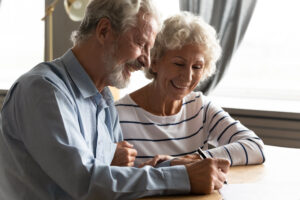 An elderly couple signing a paper