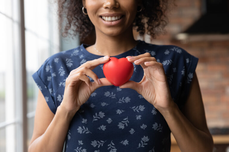 Women holding a toy heart with both her hands