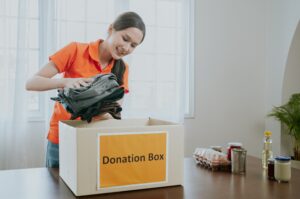 A women putting clothes in a donation box